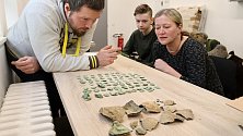Archeolog Muzea regionu Valašsko Samuel Španihel (vlevo) si spolu s nálezci paní Petrou a jejím synem Michalem prohlíží stříbrné mince objevené v Loučce na Valašskomeziříčsku.