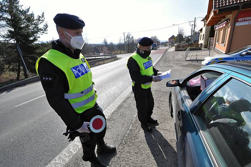 Policejní hlídka v souladu s nařízením vlády kontroluje v pondělí 1. března 2021 ve Valašských Příkazech řidiče mířící mimo okres Vsetín.