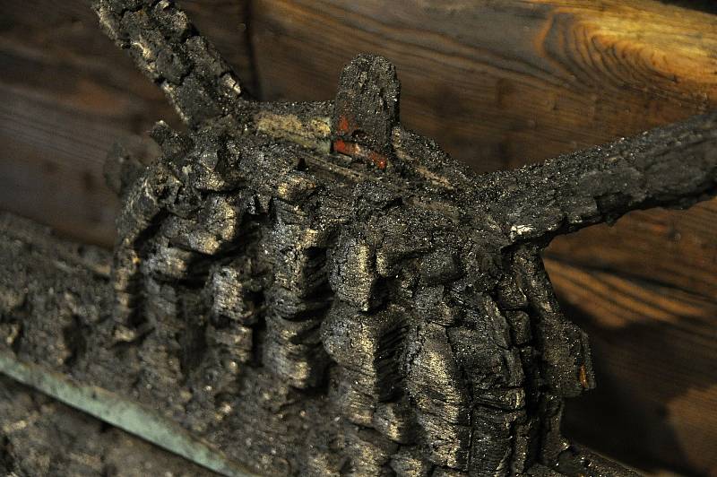 Zuhelnatělá lavice z jídelny Libušín vystavená v Sušáku ve Valašském muzeu v přírodě. Dochovala se proto, že stála u zdi. Byla tak na okraji požářiště, kde byl žár o něco slabší; Valašské muzeum v přírodě v Rožnově, Sušák, 1. patro, srpen 2020