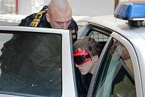 První foto. Nejotřesnějším kriminálním případem loňského roku byl případ brutální vraždy patnáctileté Petry z Dudína. Na fotografii je zachycen jeden z obviněných Michal Kisiov, kterého policie po jeho zatčení přivezla na místo činu. 