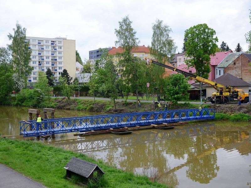 Pokládání ocelové lávky přes Sázavu.