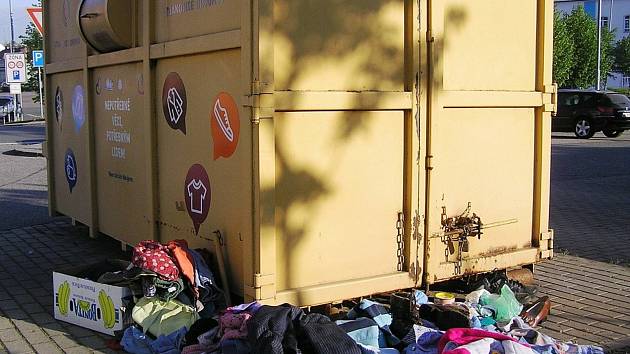 Kontejnery přetékají a staré šatstvo láká bezdomovce.