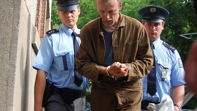 Eskorta odvádí zadrženého Slováka Antonína Nováka do hradecké vazební věznice.  
