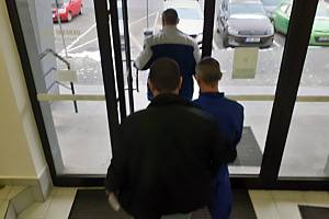 Obviněný cizinec odchází v doprovodu kriminalistů od Okresního soudu v Havlíčkově Brodě.