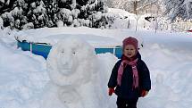 Finálový snímek č. 25: Malá Lucinka pźuje u sochy sněhového lva.