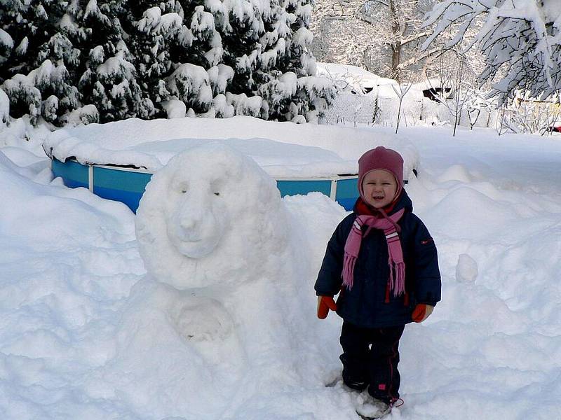 Finálový snímek č. 25: Malá Lucinka pźuje u sochy sněhového lva.