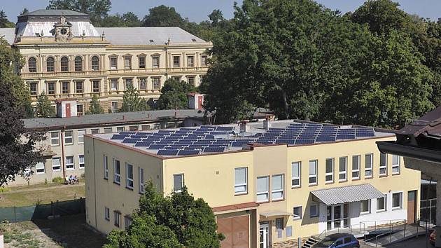 Pohled na střechu objektu osazenou fotovoltaickými panely.