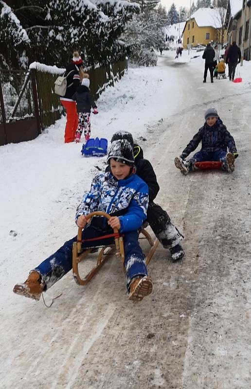 Skotačící děti v Trhové Kamenici, v pozadí sjezdovka