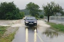 Rozvodněná Novohradka zaplavila silnici.
