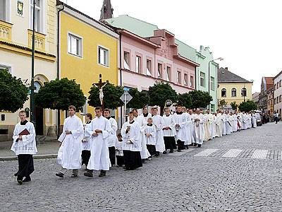 Pohřební průvod jde přes náměstí.