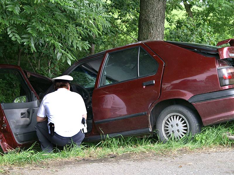 Policista zkoumá havarovaný vůz.