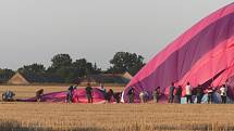 Účastníci zážitkového letu pomáhají po přistání při balení balónu.