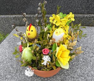 Výzdoba hrobu se snítkami kočiček, umělými květinami, vajíčky a motivy kuřátek.