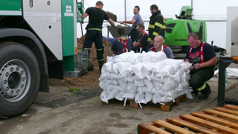 Novohradka v Úhřetické Lhotě začíná hrozit. V plné činnosti jsou hasiči z Chrudimi chystající pytle s pískem.