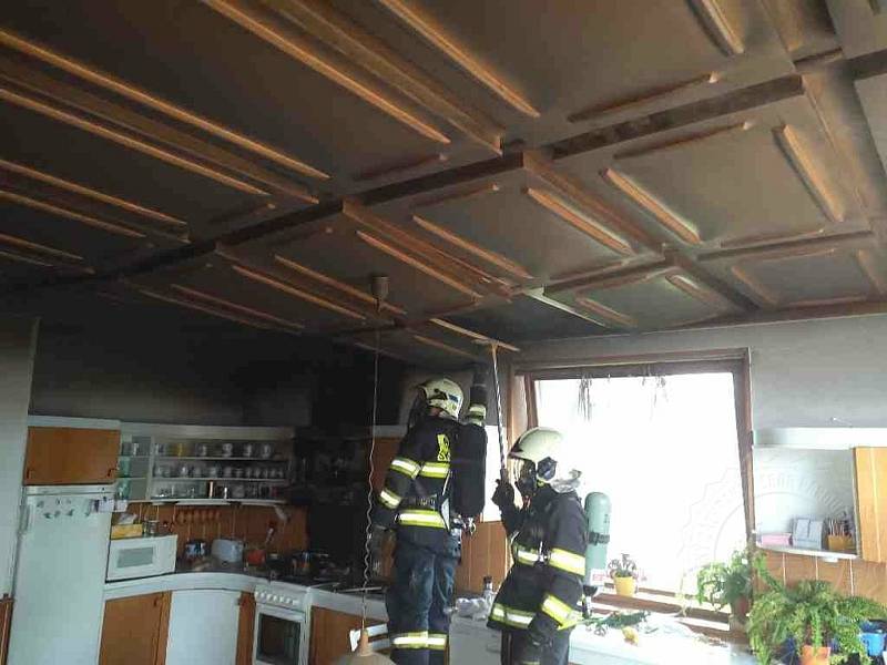 Plameny zasáhly digestoř, horní skříňky kuchyňské linky i dřevěný strop.