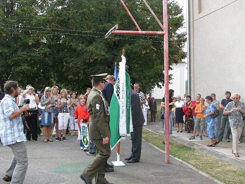 Farář Jan Paseka se chystá k vysvěcení praporu a znaku Horky za přihlížení početného obecenstva.