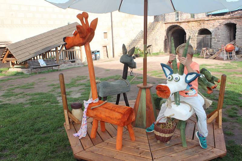 Peckovské hradní nádvoří nabízí dětem svezení na dřevěném kolotoči.