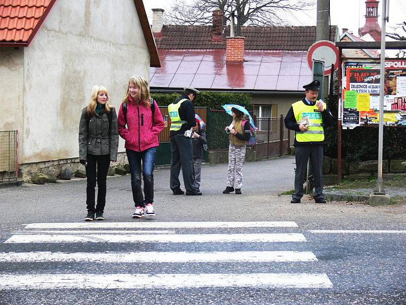 Policisté při preventivních akcích kontrolují dětí u přechodu před železnickou školou.