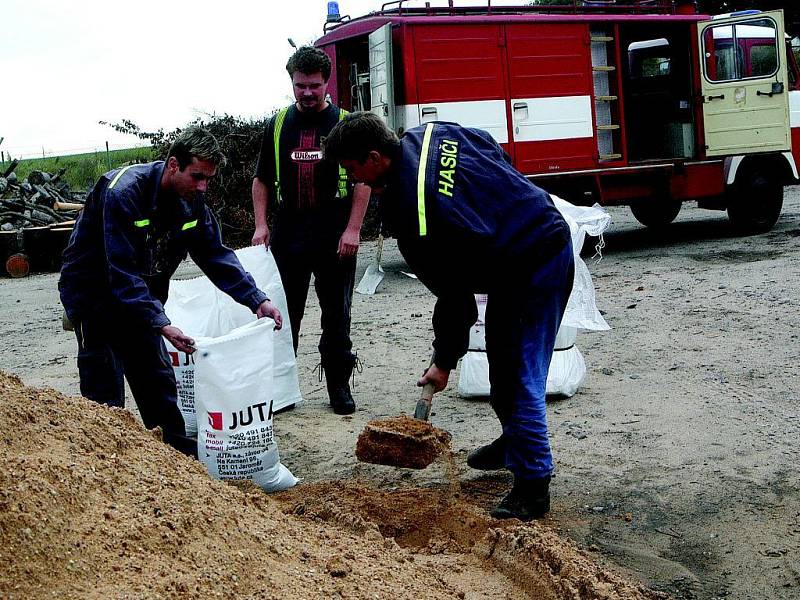 Miletínští hasiči rozdělují protipovodňové pytle.