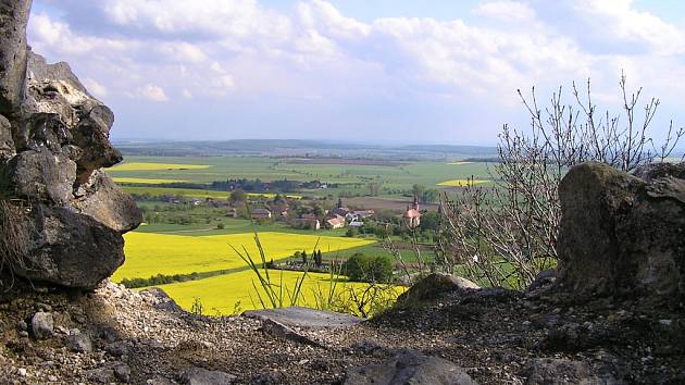 Pohled z vrchu Veliše na obec Veliš přes řepková pole.