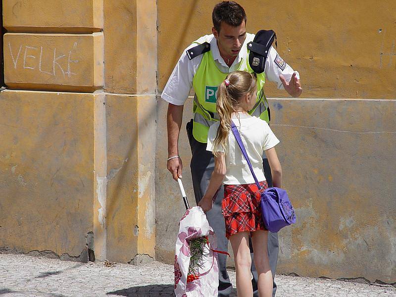 Policista Zbyněk Koreš upozorňuje školačku, kterou na přechodu málem srazilo auto, aby si příště dávala větší pozor.