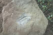 Šlápota. Uprostřed plochého kamene je vyhloubená stopa levého chodila lidské nohy. 