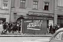 Srocení davu s nákupními taškami před samoobsluhou s potravinami na tehdejším Náměstí míru (dnes Masarykovo náměstí). Na trafice je zachycen jeden ze stovek nápisů ve městě.