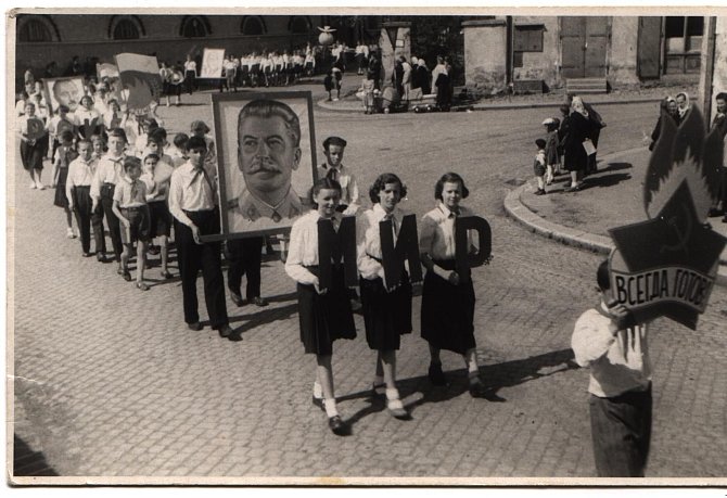 Školáci, narození koncem 2. světové války, nesou v komunistickém průvodu portrét Stalina, později označovaného za masového vraha. Na snímku1. Máj v Telči po roce 1950.