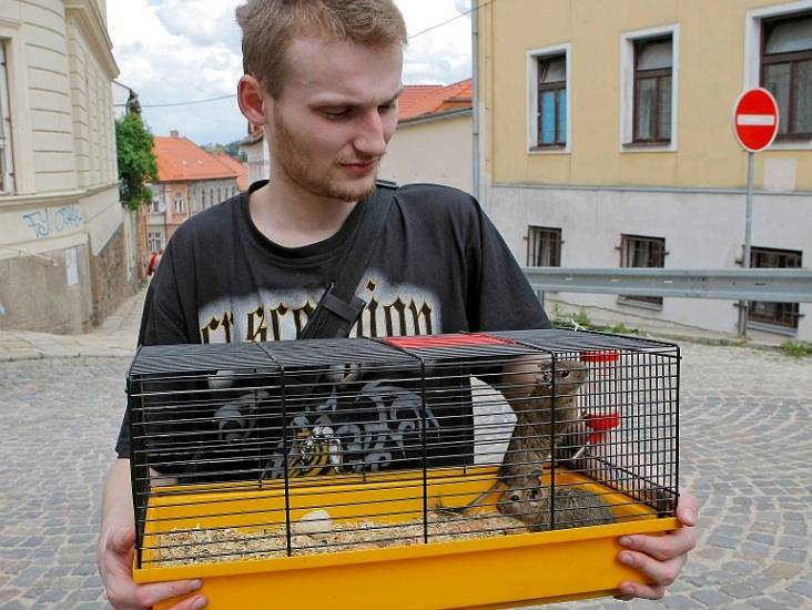 Jeden z obyvatelů vyhořelého domu vynáší z bytu osmáky.