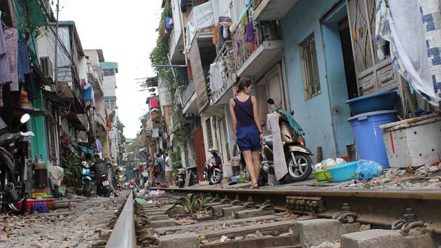 V jedné vietnamské uličce projížděl vlak. Kolej byla asi metr od pahů domů.