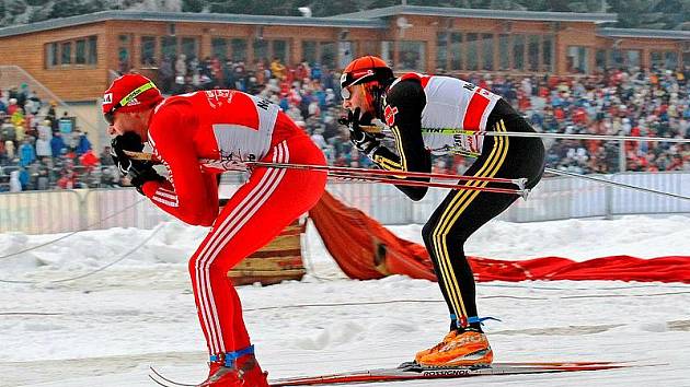 Vítěz třetího ročníku Tour de Ski Dario Cologna (vlevo) letos před zaplněnou tribunou neprosviští.