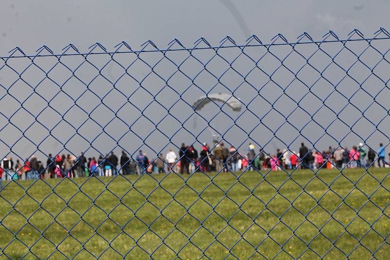 PARAŠUTISTÉ A VRTULNÍK. Návštěvníci akce k výročí paravýsadku Out Distance si mohli prohlédnout vojenský vrtulník Armády České republiky. Parašutisté se potom snesli z nebe.