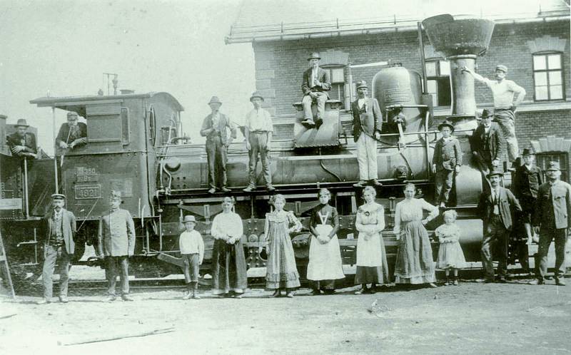 Parní mašiny byly pro zaměstnance dráhy i jejich rodiny divem techniky. Společnost se fotí před novou budovou jihlavského městského nádraží.