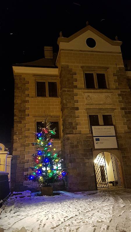 Procházka historickou Telčí v předvánočním období. Náměstí zdobí velký strom a výzdoba u morového sloupu.