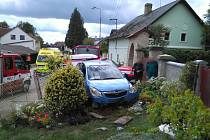 Modrý Opel nedobrovolně zaparkoval na zahrádce rodinného domu.