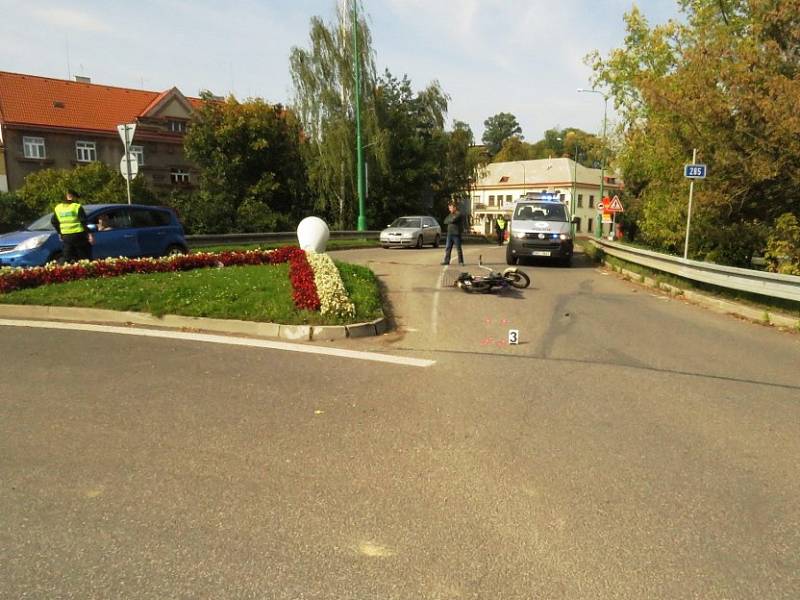 Řidič nákladního vozidla zřejmě nedal přednost motocyklistce na Babetě a vjel na kruhový objezd v době, kdy jej 67letá žena projížděla.Ta se sice vyhnula střetu s kamionem vzápětí ale přepadla z motocyklu na vozovku.