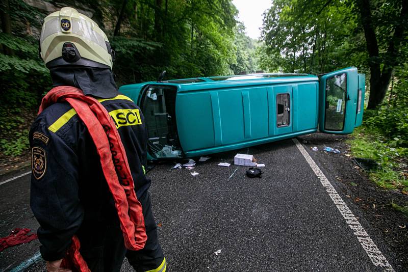 Automobil se převrátil při nehodě přes střechu a zůstal ležet na boku mimo komunikaci. Zpět na kola ho dostali hasiči.