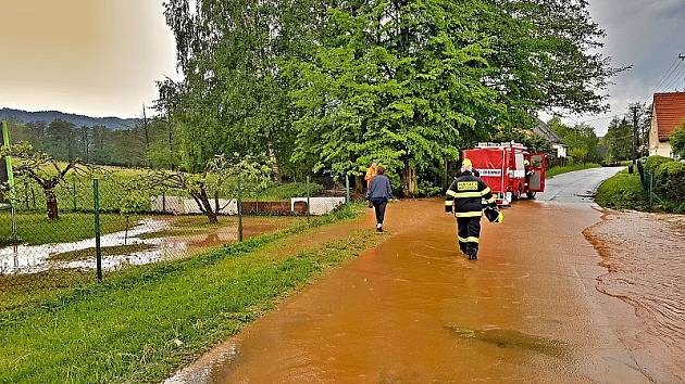 Rozvodněný potok v Křinicích ohrožoval rodinný dům. Hasiči ze Stanice Broumov, JSDH Broumov a JSDH Křinice stavěli zábrany z pytlů s pískem a dřevěných podlážek.