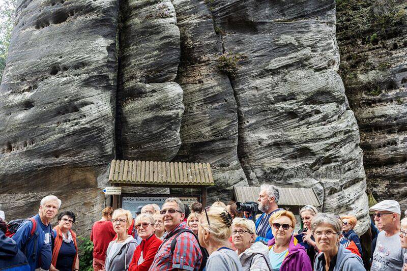 Skupina turistů si prohlíží pískovcové skály. Přeplněno zde bylo zejména kvůli polskému státnímu svátku Nanebevzetí Panny Marie.