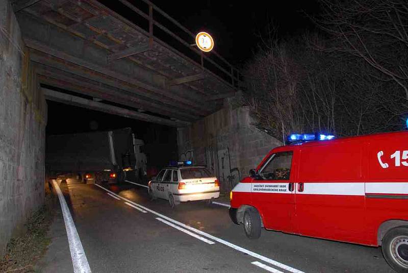 Hasiči vyprošťují kamion, který je vzpříčený přes celou šíři vozovky. 