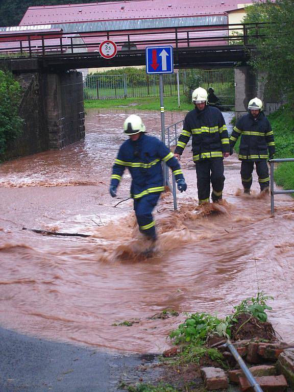 Hasiči zasahují v Olivětíně u Broumova, kde na Svinském potoku došlo k ucpání vpustě a následnému rozlití na vozovku pod železniční most.