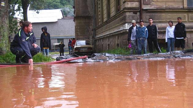 Hasiči zasahují v Olivětíně u Broumova, kde na Svinském potoku došlo k ucpání vpustě a následnému rozlití na vozovku pod železniční most.