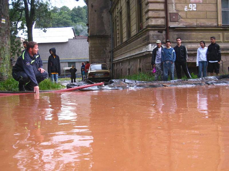 Hasiči zasahují v Olivětíně u Broumova, kde na Svinském potoku došlo k ucpání vpustě a následnému rozlití na vozovku pod železniční most.