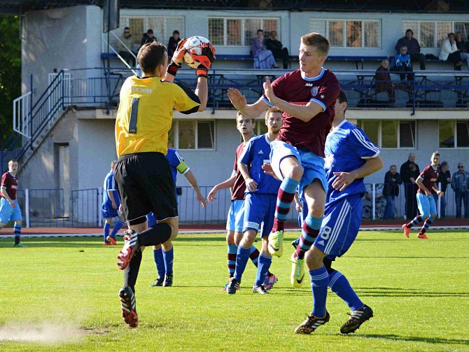 Brankář Patrik Vízek sbírá míč ze vzduchu.