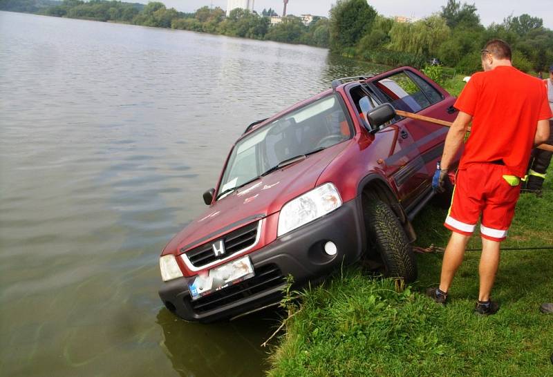 Řidič červené Hondy chtěl vycouvat, ale místo toho se rozjel dopředu, přímo k vodní hladině. Ještě však stihl zatočit, takž nevjel do vody přímo, ale dvěma koly zůstal na trávě.