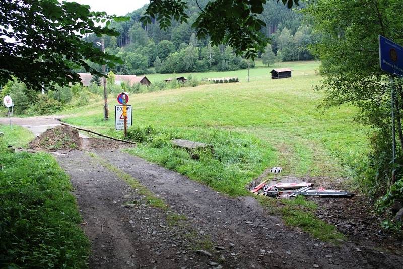 I přes stavbu a několikerý zákaz vjezdu se přes přechod jezdí přes zátarasovou hromadu i po louce.