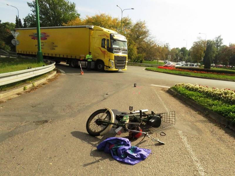 Řidič nákladního vozidla zřejmě nedal přednost motocyklistce na Babetě a vjel na kruhový objezd v době, kdy jej 67letá žena projížděla.Ta se sice vyhnula střetu s kamionem vzápětí ale přepadla z motocyklu na vozovku.