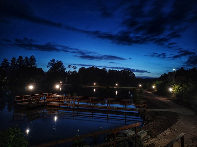 Nové dřevěné molo, lavičky, osvětlení i sochy z topolového dřeva zdobí dosud zanedbané břehy rybníku u zámku v Meziměstí na Náchodsku.