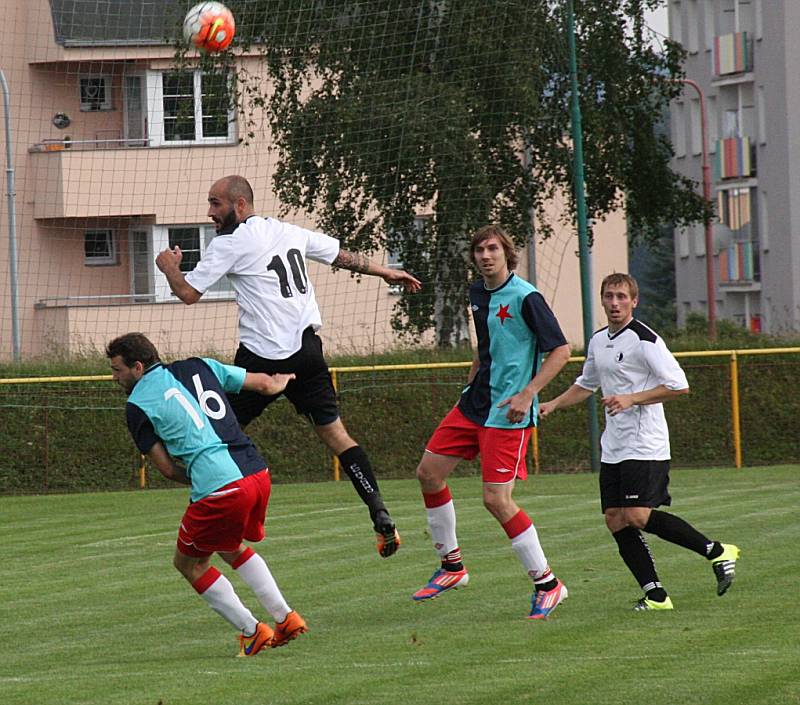  Rychnovský záložník Lukáš Reichl (č. 10) odvrací míč před dvojicí hráčů hradecké Slavie.