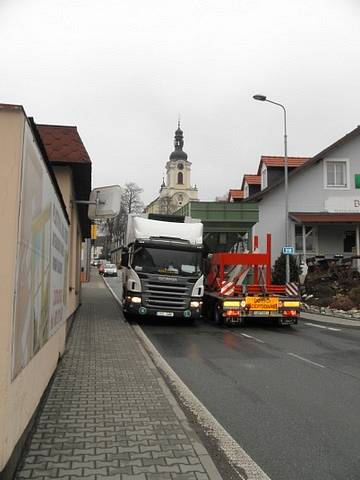 KAMIONY ZAKLESLÉ DO SEBE, kamiony v protisměru. Mezi tím vším osobní auta, školáci a obyvatelé Častolovic – strach o vlastní život i o majetek. Otřesy a hluk trápí také místní podnikatele – praskají jim výlohy, vysoké náklaďáky strhávají reklamy na domech